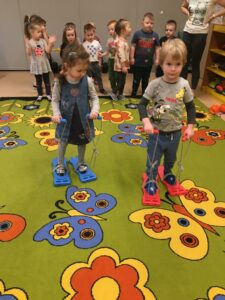 Dzieci idą w plastikowych nartach