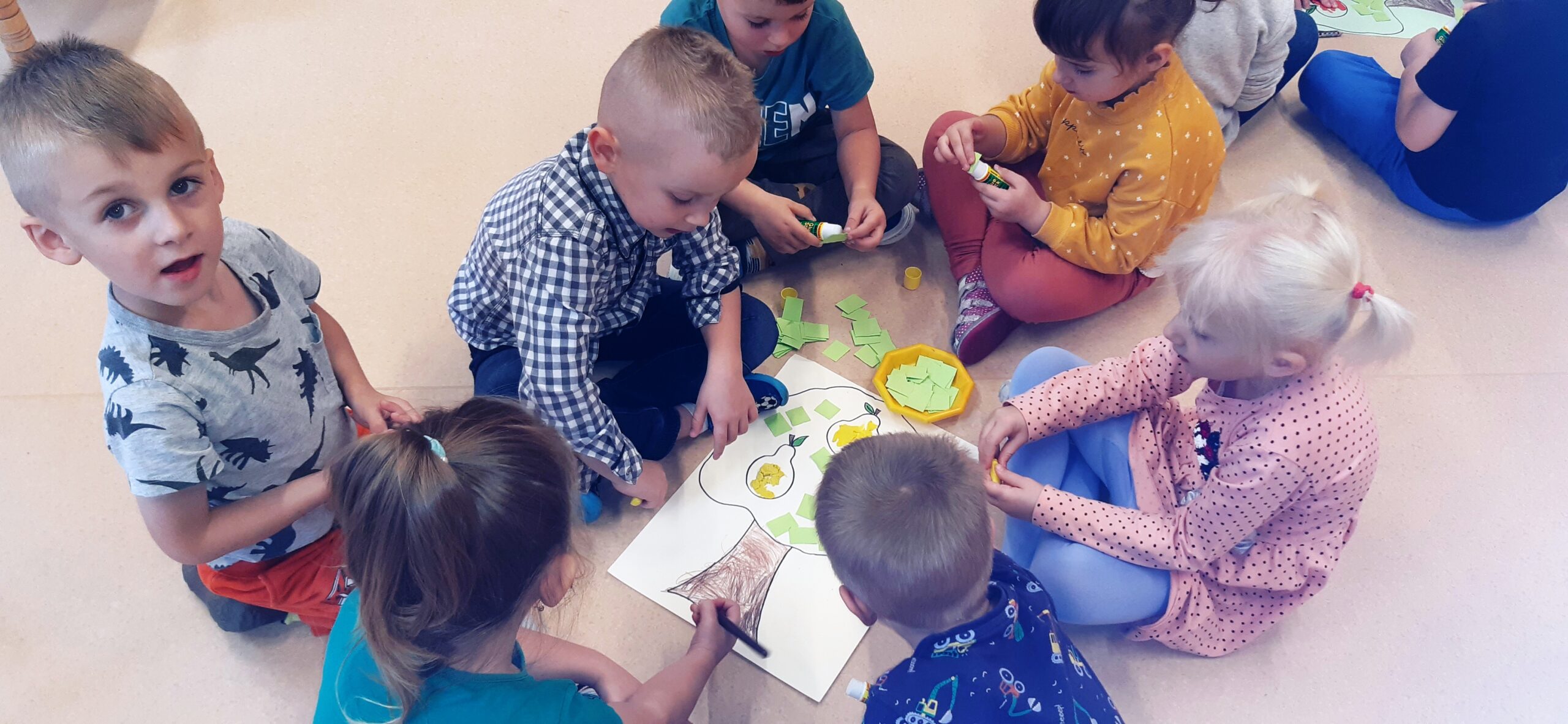 dzieci wyklejają obrazek gruszy